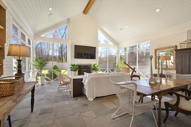 sunroom / solarium with lofted ceiling with beams and a healthy amount of sunlight