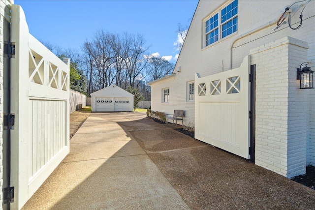 view of side of property with a garage, brick siding, and an outdoor structure