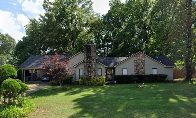 ranch-style house with stone siding, an attached carport, and a front yard