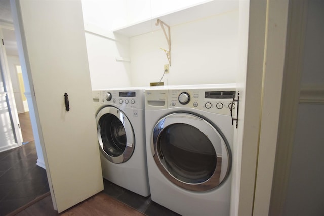 laundry room featuring laundry area, dark tile patterned flooring, and washing machine and clothes dryer