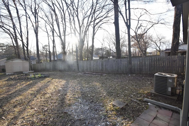 view of yard featuring a storage unit, an outdoor structure, a fenced backyard, and central air condition unit