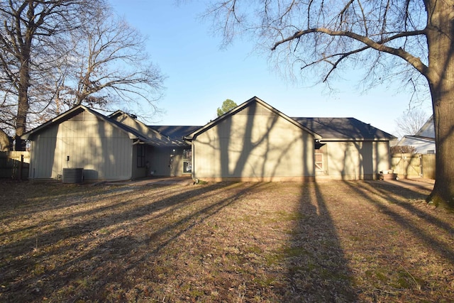 exterior space with dirt driveway, an attached garage, fence, and central air condition unit