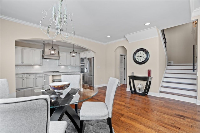 dining room featuring baseboards, ornamental molding, recessed lighting, dark wood-style floors, and arched walkways