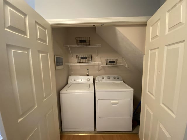 clothes washing area with laundry area, wood finished floors, and independent washer and dryer