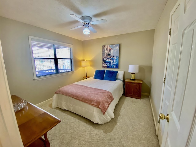 bedroom with light carpet, ceiling fan, and baseboards