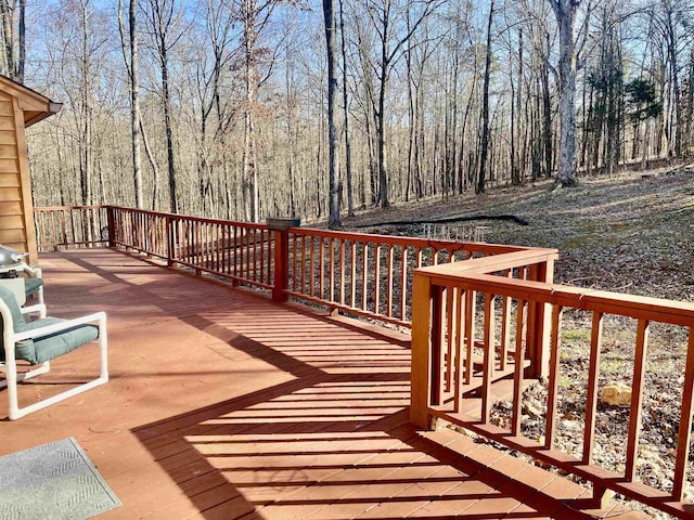 wooden terrace featuring a view of trees