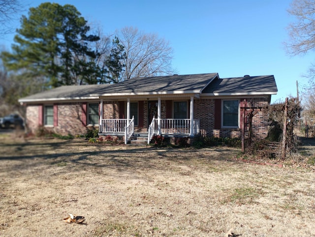 single story home with a porch and brick siding