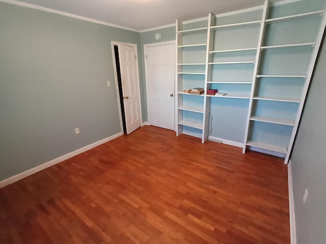 unfurnished bedroom featuring crown molding, baseboards, and wood finished floors