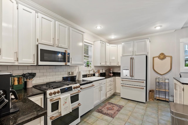 kitchen featuring white cabinets, a sink, backsplash, and high quality appliances