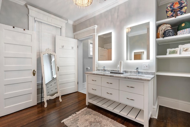 bathroom with double vanity, a sink, ornamental molding, and wood finished floors