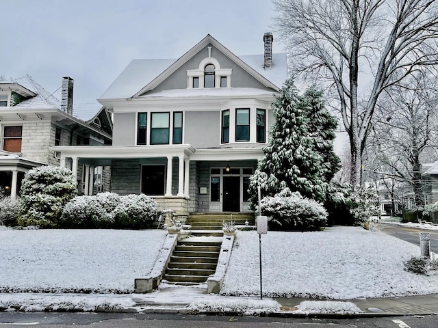 view of front of property with stairs, a chimney, and stucco siding