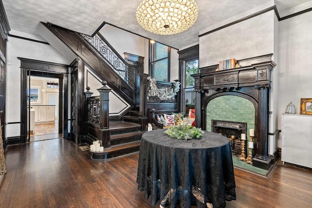 interior space featuring a towering ceiling, wood-type flooring, a fireplace, and stairway