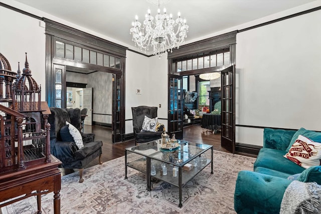 living area with an inviting chandelier, baseboards, and wood finished floors