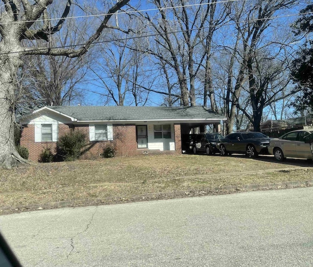 ranch-style house with roof with shingles, a carport, and brick siding