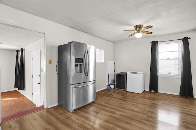 kitchen with a ceiling fan, stainless steel refrigerator with ice dispenser, wood finished floors, and refrigerator