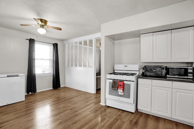 kitchen featuring a toaster, white cabinets, ceiling fan, light wood-type flooring, and white range with gas stovetop