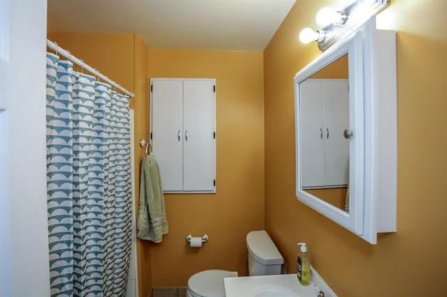 bathroom featuring curtained shower and toilet