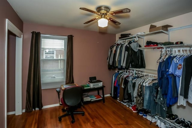 walk in closet with a ceiling fan and wood finished floors