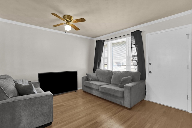 living room with light wood-type flooring, ornamental molding, and a ceiling fan