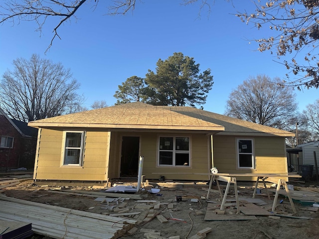 view of front of property featuring a shingled roof and a patio