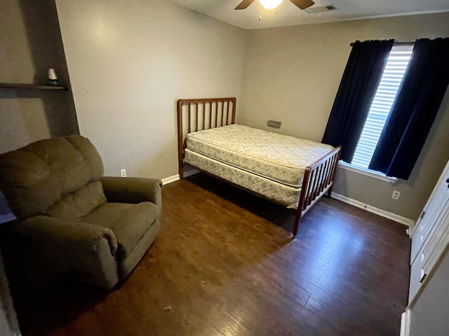 bedroom with multiple windows, visible vents, baseboards, and wood finished floors