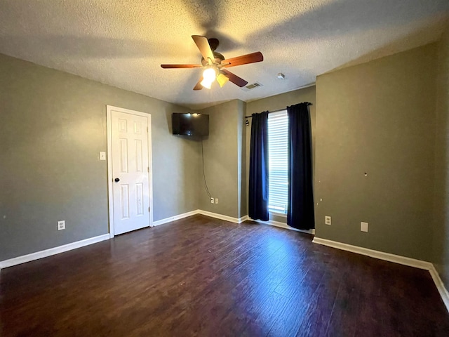 unfurnished room with baseboards, visible vents, dark wood-style floors, ceiling fan, and a textured ceiling