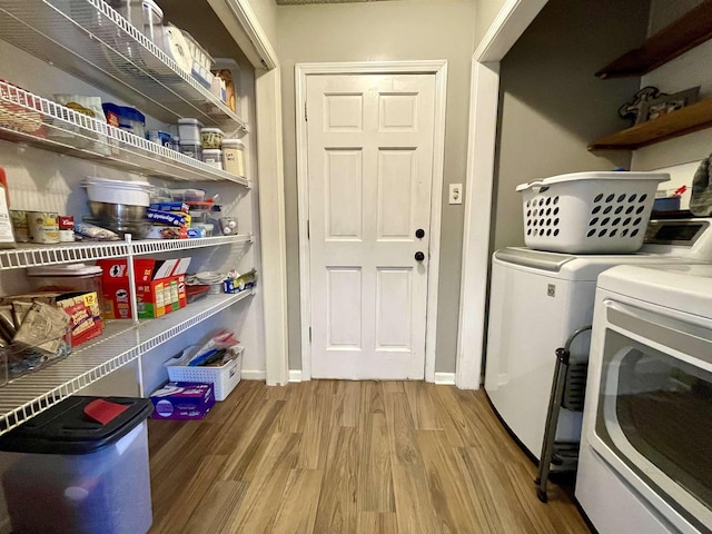 washroom with laundry area, independent washer and dryer, baseboards, and wood finished floors