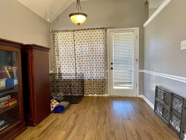 dining area featuring lofted ceiling, baseboards, and wood finished floors