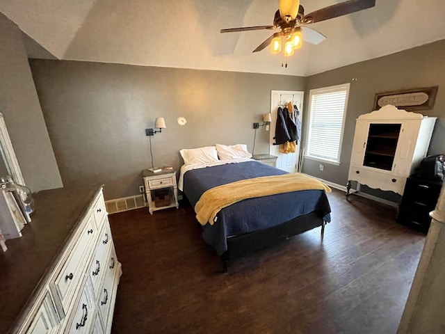 bedroom with dark wood-style floors, lofted ceiling, ceiling fan, and baseboards