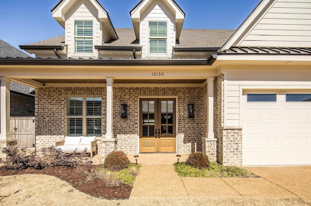 entrance to property featuring french doors, brick siding, a shingled roof, a standing seam roof, and metal roof