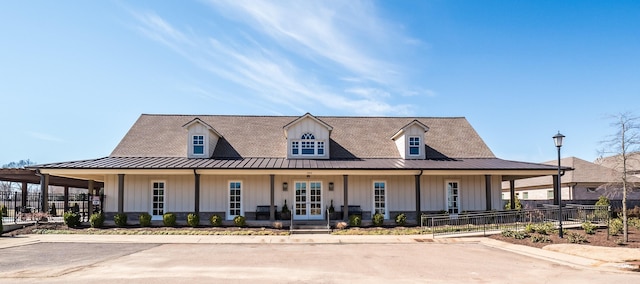 view of front of home with a standing seam roof, fence, a porch, and board and batten siding