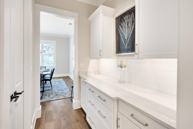 interior space with crown molding, baseboards, and dark wood-type flooring