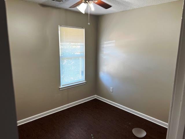 unfurnished room featuring ceiling fan, baseboards, dark wood-style flooring, and a textured ceiling