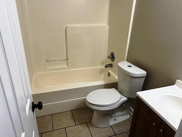 full bathroom featuring vanity, shower / washtub combination, tile patterned flooring, and toilet