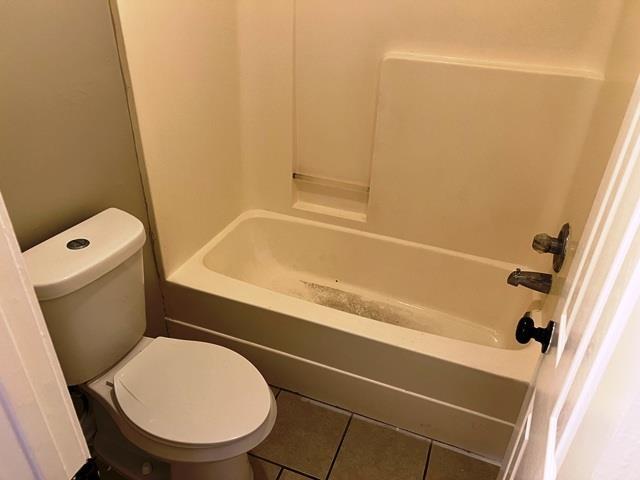 full bath with shower / bath combination, toilet, and tile patterned floors