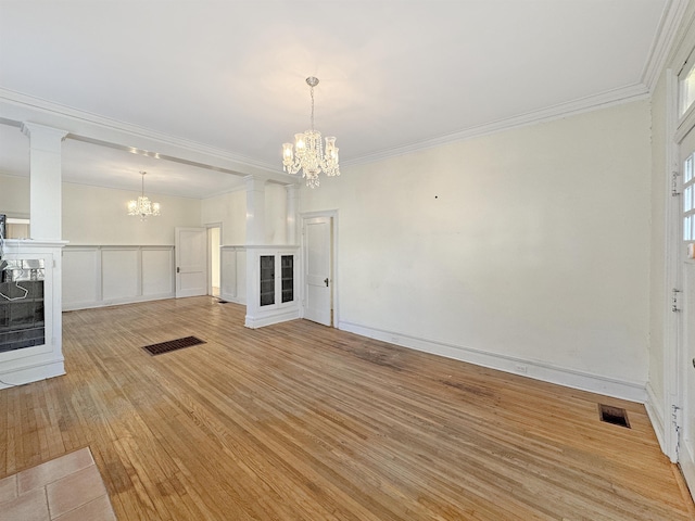 unfurnished living room with light wood-type flooring, visible vents, a notable chandelier, and a fireplace