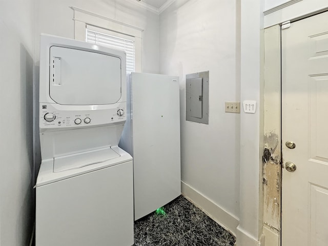 laundry room featuring stacked washer and dryer, ornamental molding, laundry area, electric panel, and baseboards