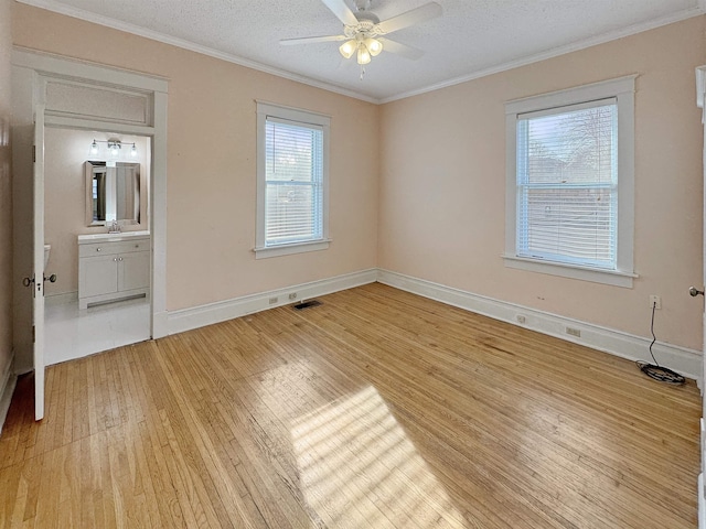 unfurnished bedroom with light wood-style flooring, multiple windows, ornamental molding, and visible vents