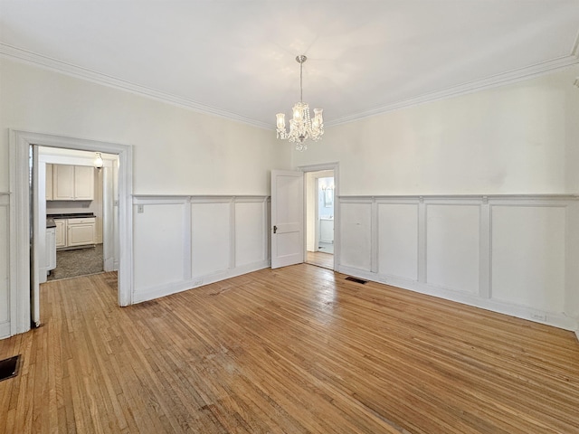 interior space featuring visible vents, crown molding, an inviting chandelier, and wood finished floors