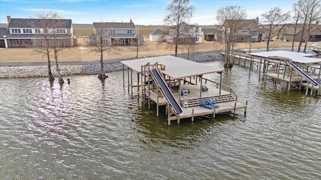 view of dock featuring a residential view, a water view, and boat lift