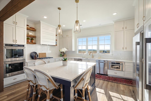 kitchen featuring decorative backsplash, appliances with stainless steel finishes, crown molding, open shelves, and a sink