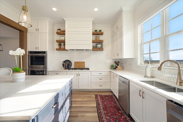 kitchen featuring appliances with stainless steel finishes, open shelves, a sink, and ornamental molding