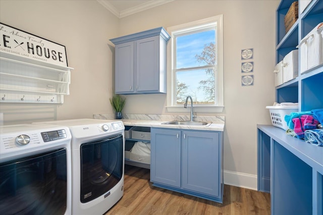 laundry area with a sink, light wood-style floors, independent washer and dryer, cabinet space, and crown molding