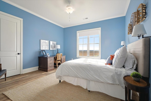 bedroom featuring baseboards, visible vents, ornamental molding, and wood finished floors