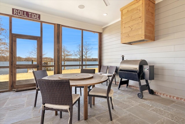 sunroom featuring a water view