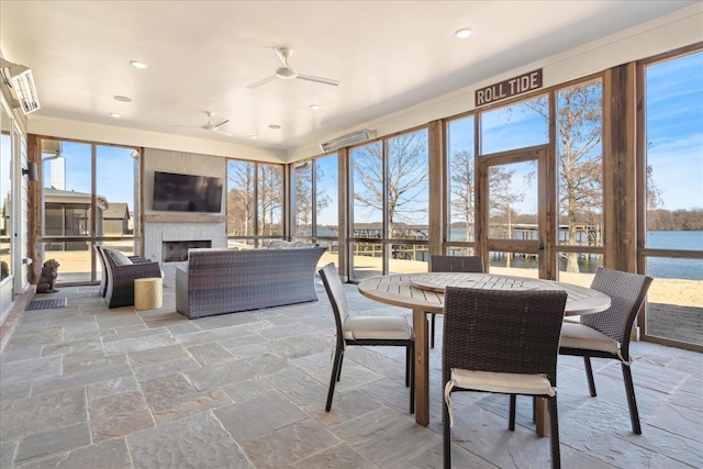 sunroom / solarium featuring ceiling fan, a fireplace, visible vents, and a healthy amount of sunlight