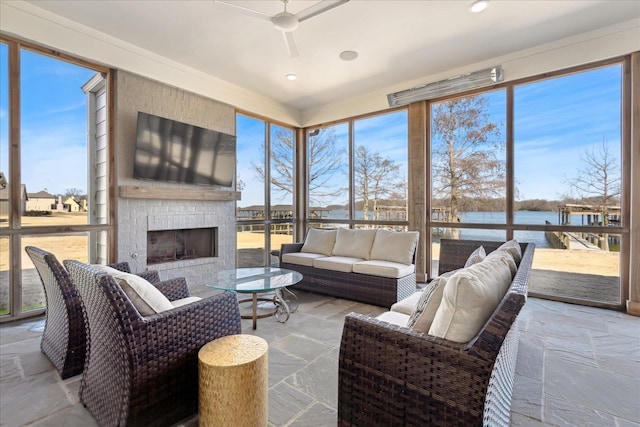 sunroom / solarium with a large fireplace and ceiling fan