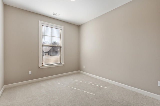 carpeted spare room with visible vents and baseboards