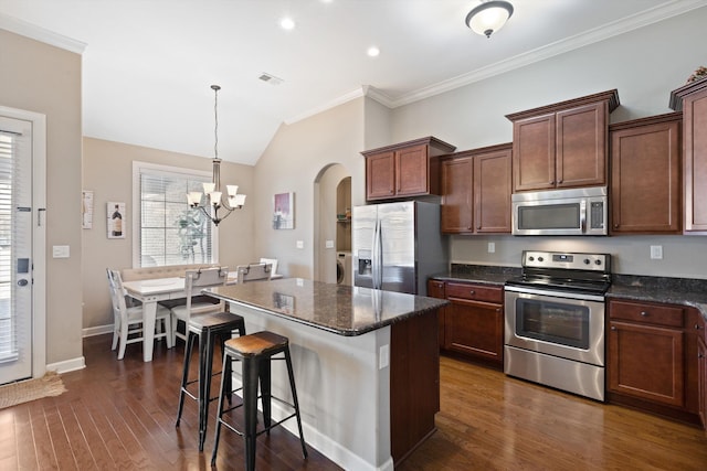 kitchen with dark wood-style floors, arched walkways, crown molding, visible vents, and appliances with stainless steel finishes