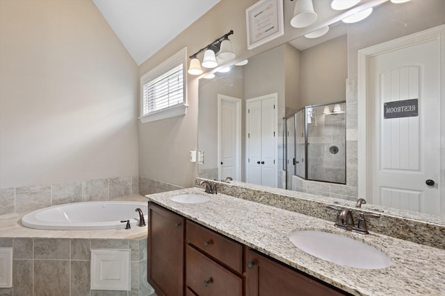 bathroom with a bath, a stall shower, vaulted ceiling, and a sink